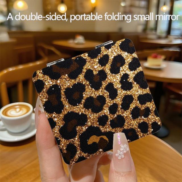 TEMU A Compact, Double-sided Folding Mirror Featuring A Leopard Print In Black And Golden Glitter, Designed For Everyday Use. This Handheld Makeup Mirror Embodies A Aesthetic